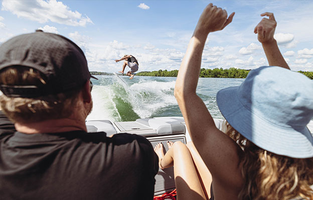 Girl throws up hands while surfing